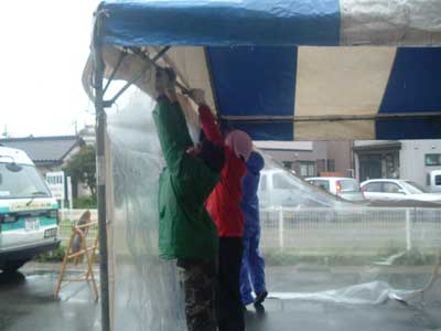 雨の中テントを組み立て中 当日朝の準備風景