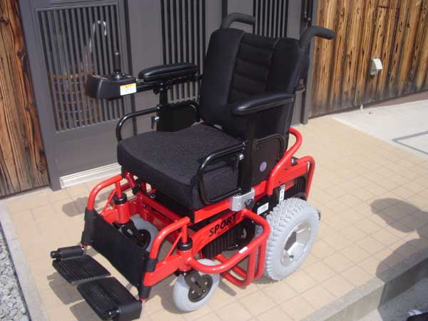 電動車椅子の画像です。フレームが赤、クッションなどが黒のツートンカラーになっています。
